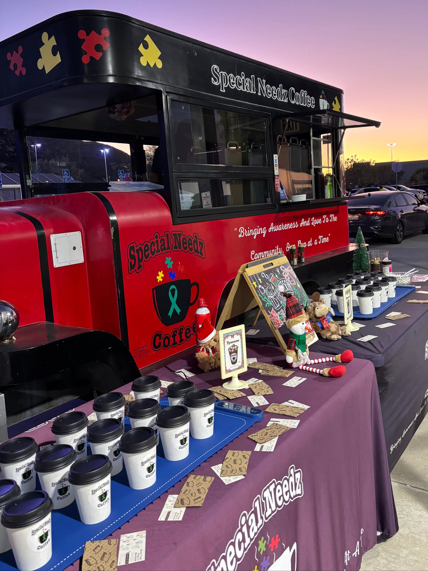 Special Needs Coffee truck with merchandise display at an outdoor event.
